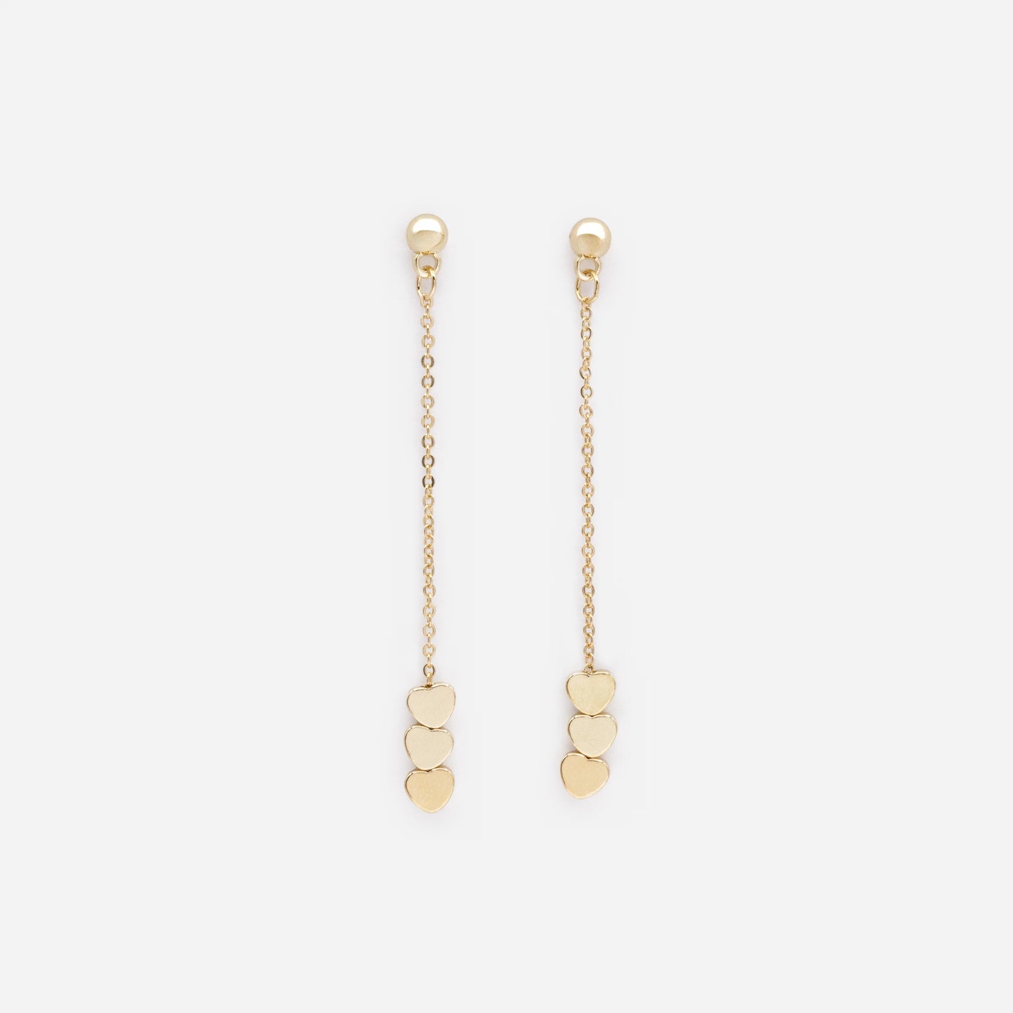 Long golden earrings with flat heart trio